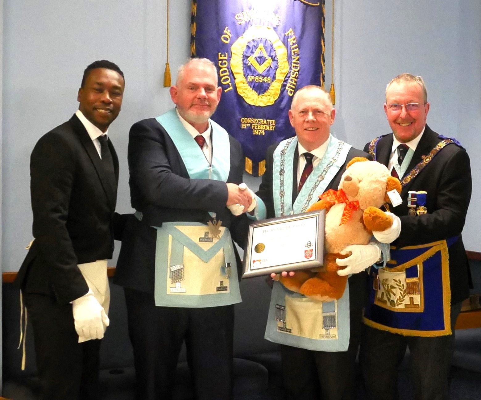 TLC Provincial Representative W. Bro Campbell presents the Patron Certificate and TLC Teddy Bear.