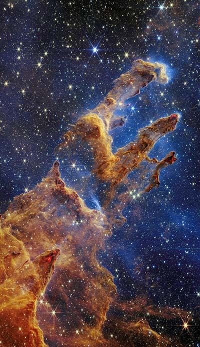 The Pillars of Creation are set off in a kaleidoscope of color in NASA's James Webb Space Telescope's near-infrared-light view. The pillars look like arches and spires rising out of a desert landscape, but are filled with semi-transparent gas and dust, and ever changing. This is a region where young stars are forming - or have barely burst from their dusty cocoons as they continue to form.
Newly formed stars are the scene-stealers in this Near-Infrared Camera (NIRCam) image. These are the bright red orbs that sometimes appear with eight diffraction spikes. When knots with sufficient mass form within the pillars, they begin to collapse under their own gravity, slowly heat up, and eventually begin shining brightly.
Along the edges of the pillars are wavy lines that look like lava. These are ejections from stars that are still forming. Young stars periodically shoot out supersonic jets that can interact within clouds of material, like these thick pillars of gas and dust. This sometimes also results in bow shocks, which can form wavy patterns like a boat does as it moves through water. These young stars are estimated to be only a few hundred thousand years old, and will continue to form for millions of years.
Although it may appear that near-infrared light has allowed Webb to 