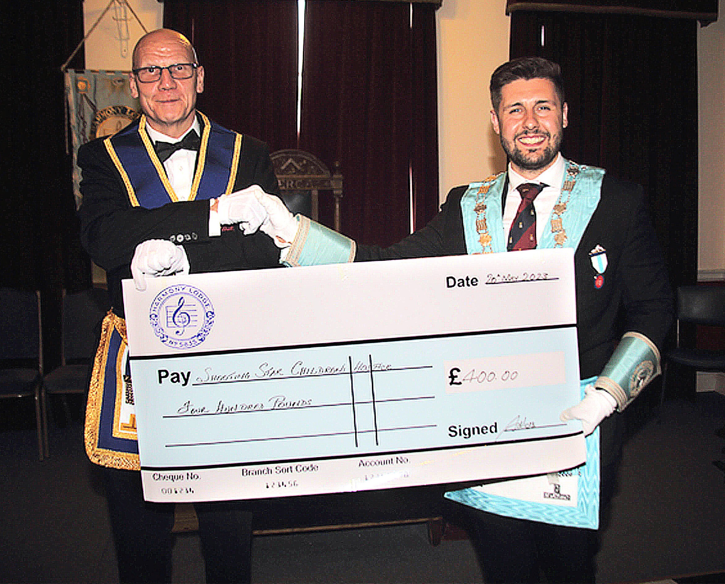 W. Bro Martin Burt ProvSGW of Everest Base Camp fame receives a cheque for £400 from the new Master of Harmony Lodge for the Shooting Star Children's Hospices Charity - W. Bro Rafał Walczak